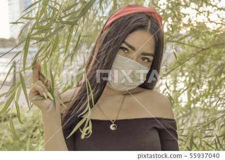 Asian Woman Wear Face Mask Outdoor In The Branches Of Willow Asian Woman Wear Face Mask Outdoor In The Branches Of Willow 55937040