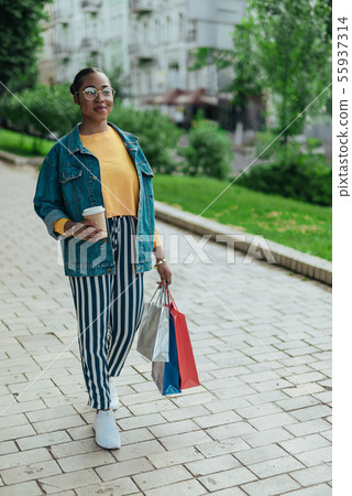 Young afro american woman is walking outdoors Young afro american woman is walking outdoors 55937314