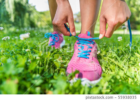 Runner woman getting ready tying running shoes Runner woman getting ready tying running shoes 55938035