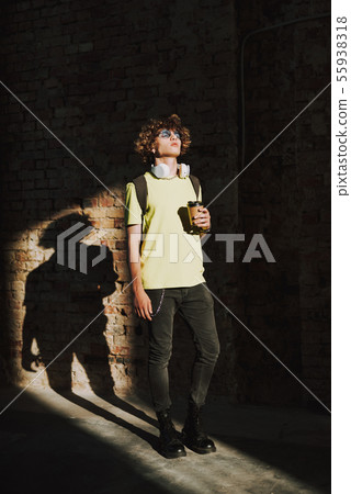 Relaxed man in shadow is holding coffee Relaxed man in shadow is holding coffee 55938318