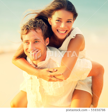Romantic couple having fun piggyback on beach Romantic couple having fun piggyback on beach 55938786