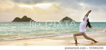 Yoga woman meditating in warrior I pose at beach Yoga woman meditating in warrior I pose at beach 55940200