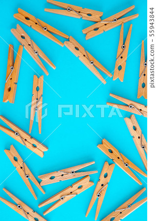 Wooden yellow clothespins are scattered on a 55943844