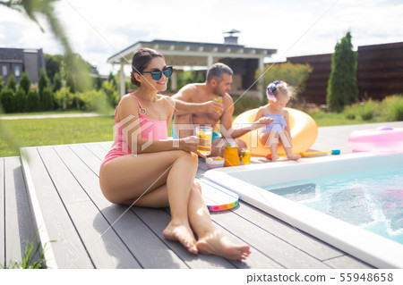 Beautiful slim woman sunbathing near husband and daughter 55948658