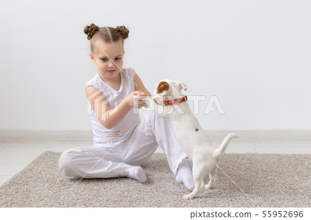 people, children and pets concept - little child girl sitting on the floor with cute puppy Jack 55952696