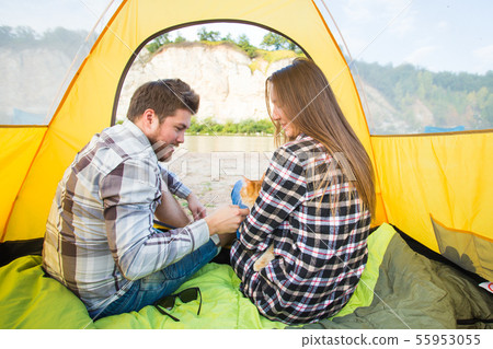 people, summer tourism and nature concept - young couple resting in camping tent, view from inside people, summer tourism and nature concept - young couple resting in camping tent, view from inside 55953055
