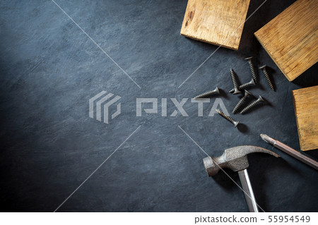 Hammer and lumber on black cement background. Hammer and lumber on black cement background. 55954549