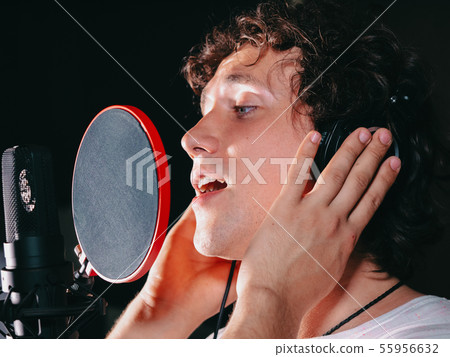 Male vocal artist with curly hair singing alone.Singer man writing song Male vocal artist with curly hair singing alone.Singer man writing song 55956632