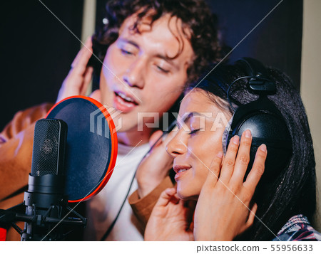 Young team singers performing song in record studio.Professional musician duet 55956633