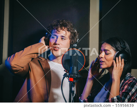 Young team singers performing song in record studio.Professional musician duet 55956639