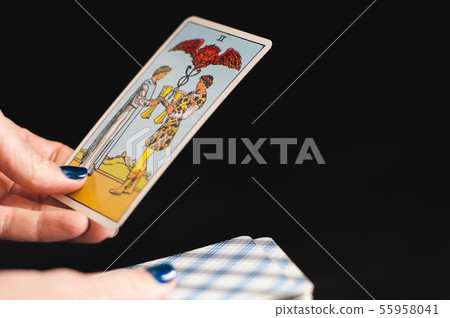 Tarot cards senior Arcana in the hands of a woman on a black background Tarot cards senior Arcana in the hands of a woman on a black background 55958041