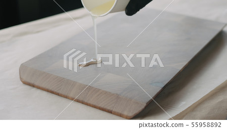 woodworker applying oil finish to walnut end grain wood board 55958892