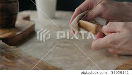 woodworker applying oil finish to olive wood scoop woodworker applying oil finish to olive wood scoop 55959141