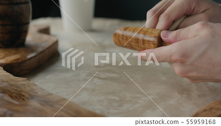 woodworker applying oil finish to olive wood scoop woodworker applying oil finish to olive wood scoop 55959168