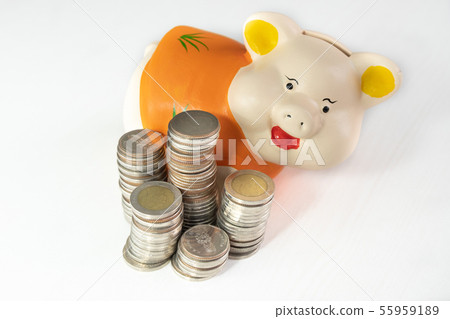 saving money with Orange piggy bank and coins pile saving money with Orange piggy bank and coins pile 55959189