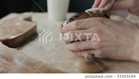woodworker applying oil finish to olive wood pot woodworker applying oil finish to olive wood pot 55959194