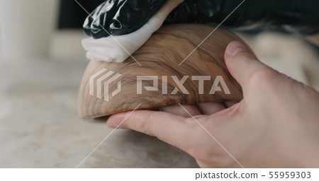 woodworker applying oil finish to olive wood bowl woodworker applying oil finish to olive wood bowl 55959303
