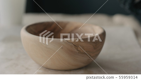 woodworker applying oil finish to olive wood bowl 55959314