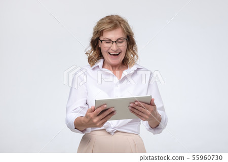 Laughing senior woman using tablet computer to buy some stuff 55960730
