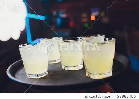 Lemon rosemary cocktail in glasses on a tray. Lemon rosemary cocktail in glasses on a tray. 55962499