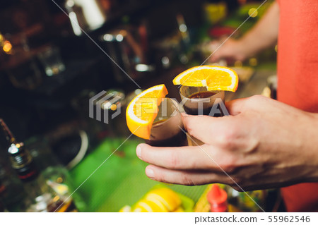 Jagermeister Shots cocktails with orange hand male. Jagermeister Shots cocktails with orange hand male. 55962546