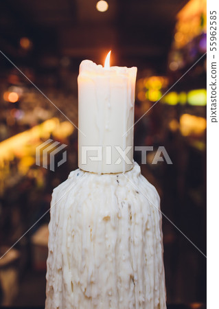 closeup of a burning candle on a dark background with soft lighting. closeup of a burning candle on a dark background with soft lighting. 55962585
