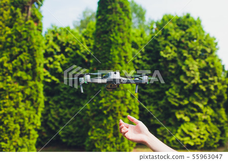 man and his drone, quadrocopter in a forest on a green background. 55963047