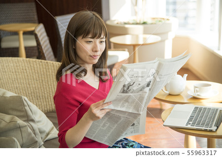 A woman reading a newspaper Cafe Lounge 55963317