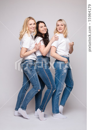 Side view of beautiful young women standing one by Side view of beautiful young women standing one by 55964179