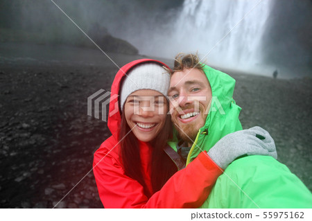 Selfie couple taking smartphone picture waterfall 55975162