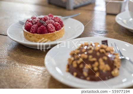 Raspberries Tart and Chocolate dome cake on plate 55977194