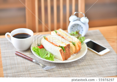 Breakfast, morning lifestyle image. Sandwich, coffee, smartphone, smartphone, alarm clock. 55978297