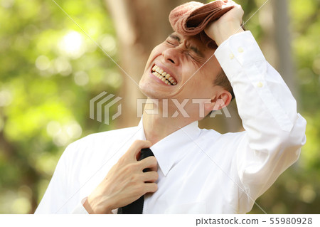 Male employee wipes sweat with towel Male employee wipes sweat with towel 55980928