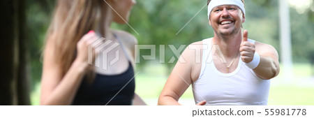 Fatty millennial man running in park with 55981778
