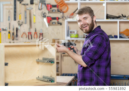 Manufacturing, Small-Sized Companies and worker concept - man working on the furniture factory Manufacturing, Small-Sized Companies and worker concept - man working on the furniture factory 55981892