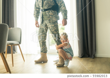 Little blonde girl hugging her father leg while he leaving house Little blonde girl hugging her father leg while he leaving house 55982013