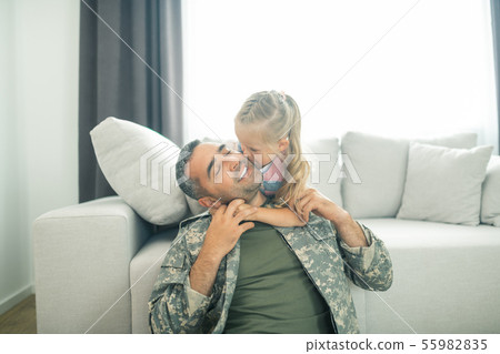 Loving daughter kissing her father being hero for the family Loving daughter kissing her father being hero for the family 55982835