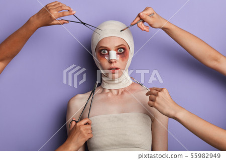 frightened girl wrapped into the bandage looking at the camera frightened girl wrapped into the bandage looking at the camera 55982949