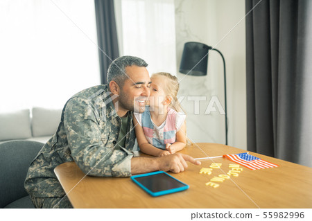 Daughter kissing father coming home after military service Daughter kissing father coming home after military service 55982996