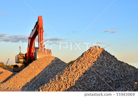 Large tracked excavator works in a gravel pit. Large tracked excavator works in a gravel pit. 55983069