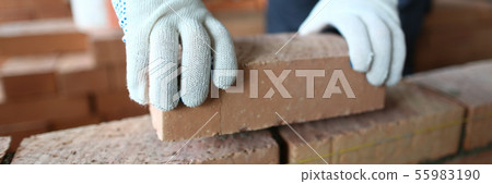 Male hands putting brick 55983190