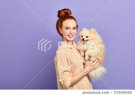 good looking girl in stylish shirt lifting her pet good looking girl in stylish shirt lifting her pet 55984089