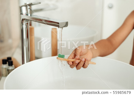 The child brushes teeth with a bamboo toothbrush. The child brushes teeth with a bamboo toothbrush. 55985679