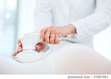 Woman in white suit getting LPG procedure , body contouring treatment in clinic. 55987461