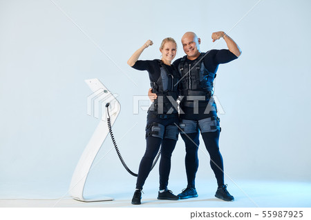 positive powerful couple in EMS suits with raised arms looking at the camera positive powerful couple in EMS suits with raised arms looking at the camera 55987925