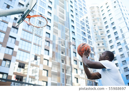 African Man Throwing Ball to Hoop 55988697