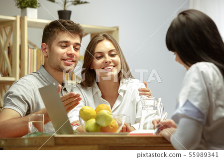 Smiling nutritionist showing a healthy diet plan to patient Smiling nutritionist showing a healthy diet plan to patient 55989341