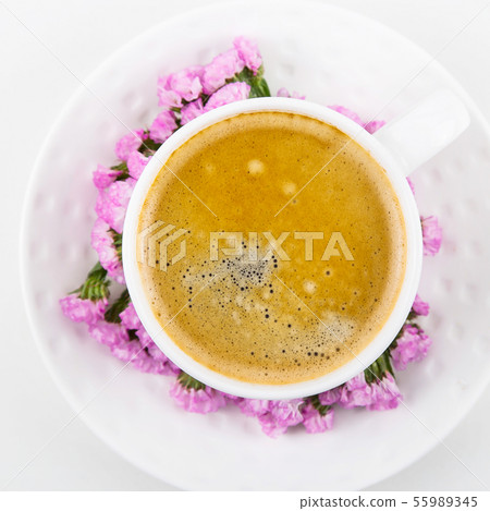 Yellow flowers and cup on a white table Yellow flowers and cup on a white table 55989345
