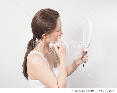 A woman troubled watching a mirror A woman troubled watching a mirror 55989592