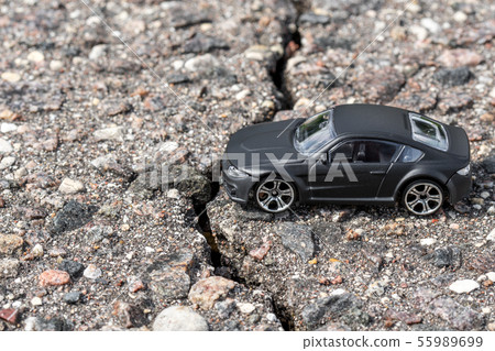 Car beside crack in the pavement 55989699